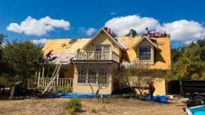 Roof replacement San Antonio TX project showing old roofing materials removed while professional roofers inspect decking, install underlayment, flashing, and new asphalt shingles.