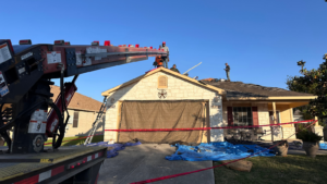 Home protection during roof replacement in San Antonio showing professional roofers protecting landscaping, windows, siding, gutters, and the surrounding property during a residential roof tear-off.
